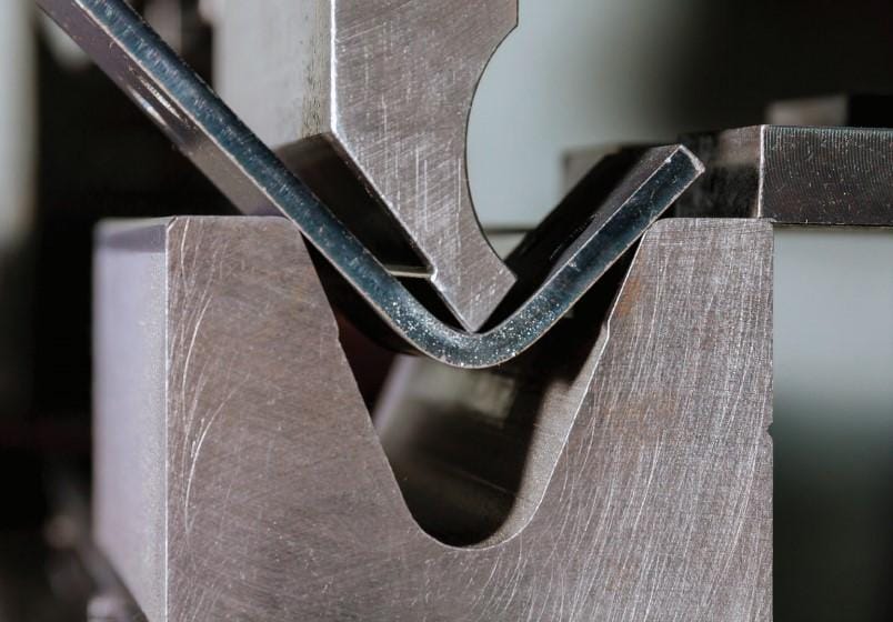 The fundamentals of press brake tooling - Pictures 12 FIGURE 8 In air bending, the die opening establishes the radius and the punch's depth of penetration into the die space establishes the bend angle. This further demonstrates how crucial it is to keep the flange length at a minimum. This bend might not fit firmly on the die if it were nearer the plate edge.